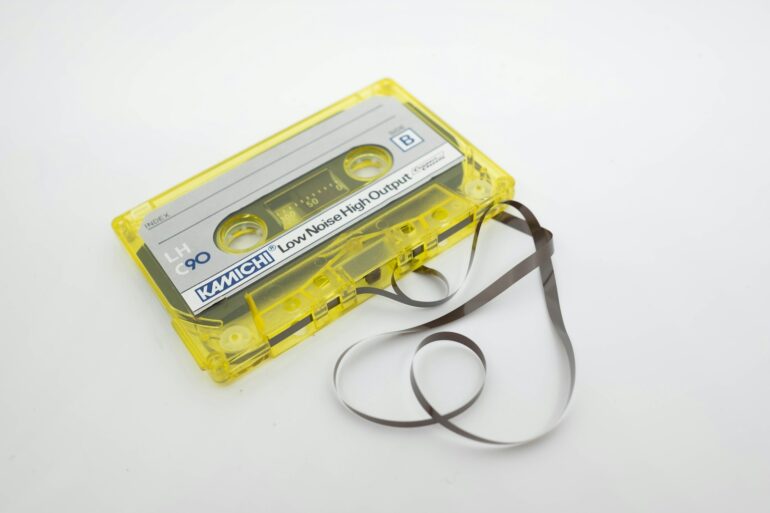 a yellow cassette cassette with a black strap