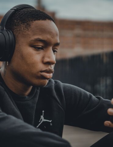 man in black nike hoodie wearing black headphones